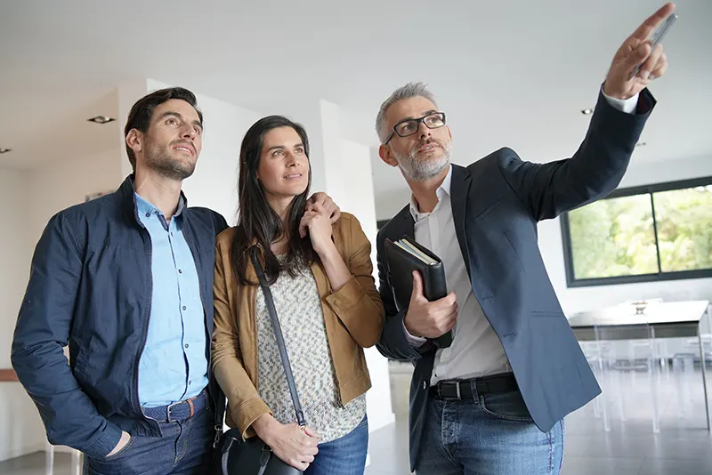 pareja inspeccionando propiedad con arquitecto en la recepción de la misma